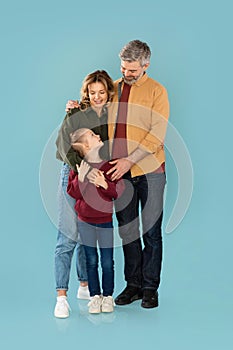 Middle Aged Parents Embracing Daughter Smiling Standing Together In Studio