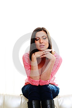 Middle-aged pensive woman sitting on the sofa