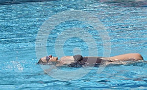 Middle aged pregnant woman swimming in spa pool to relax