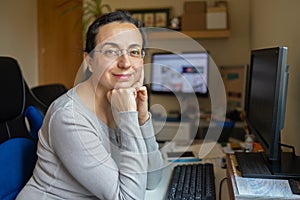 Middle aged pretty woman with glasses looking to the camera and smiling