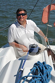 Middle-aged sailor on boat sailing