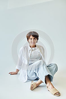 Middle aged smiling woman sitting on