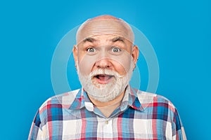 Middle aged surprised man on studio isolated background. Close up portrait of grey-haired mature senior man. Surprised