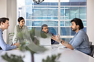 Middle-aged team leader makes speech at briefing in conference room photo