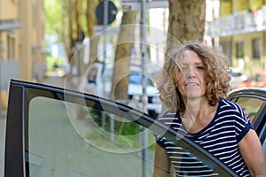 Middle-aged woman alighting from a car