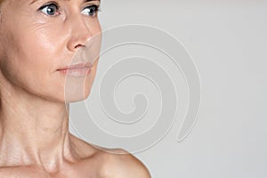 Middle-aged woman after anti-aging treatment, grey background