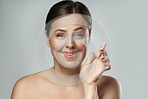 Middle aged woman applying anti-aging cream on her face