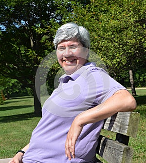Middle aged woman on bench smiling