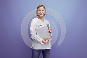 middle-aged woman with blond hair solves work tasks using a laptop