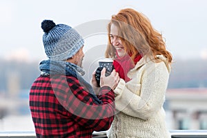 Middle aged woman with boyfriend hold hot cup of coffee. Happy woman takes cup from her man. Couple warm hands of coffee cup