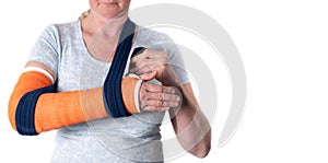 middle aged woman with broken arm in cast hangs her arm in a sling, modern treatment methods, on a neutral background