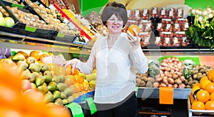 Middle aged woman choosing fruits