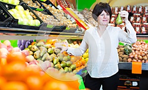 Middle aged woman choosing fruits