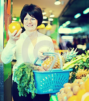 Middle aged woman choosing fruits and vegetables
