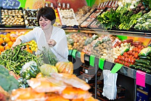 Middle aged woman choosing vegetables