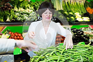 Middle aged woman choosing vegetables