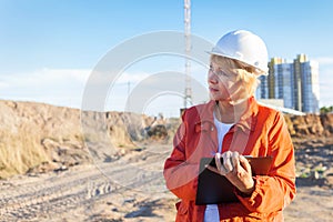 A middle aged woman on a construction site inspects the work carried out