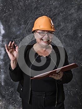 Middle-aged woman construction superintendent in helmet studio portrait. photo