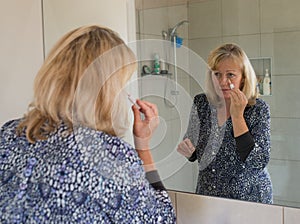 Middle-aged Woman Covering Blemishes on her Face.