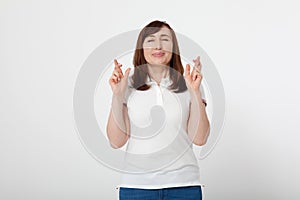 Middle aged woman crossing her fingers and wishing for good luck. Blank white t-shirt, mock up. Fashion outfit Mother day