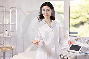 Middle aged woman doctor stands in hospital office, medical center. Modern medical care, tests, consultation