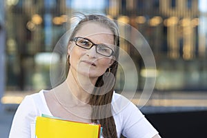 Middle aged woman with documents in hands. smart business lady, businesswoman, thoughtful teacher, pensive lecturer