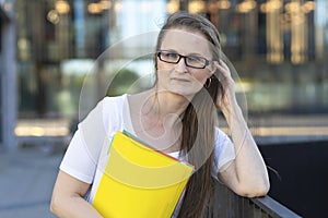 Middle aged woman with documents in hands. smart business lady, businesswoman, thoughtful teacher, pensive lecturer