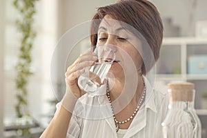 Middle aged woman drinking water