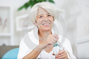 middle-aged woman drinking water after sport