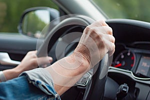 Middle aged woman driving car, holding steering wheel