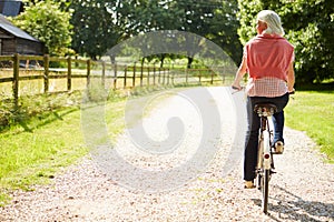 Middle Aged Woman Enjoying Country Cycle Ride