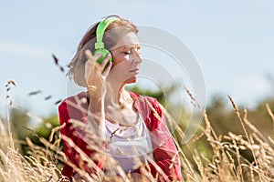 Middle aged woman enjoying quietness with music outdoors