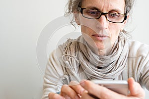 Middle aged woman with glasses and smart phone