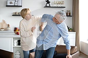 Middle-aged woman helping her husband with backache