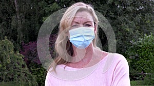 Middle aged woman in her forties outside wearing a face mask during Coronavirus COVID-19 Pandemic