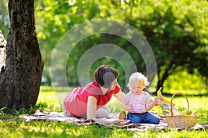 Middle aged woman and her little grandson in sunny park