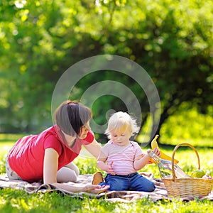 Middle aged woman and her little grandson in sunny park