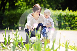 Middle aged woman and her little grandson in sunny park