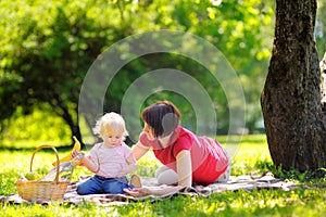 Middle aged woman and her little grandson in sunny park