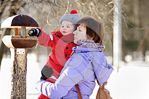 Middle aged woman and her little grandson at the winter park