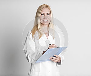 Middle aged woman holding folder writing diagnosis