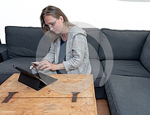 A middle aged woman at home using her laptop computer