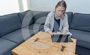 A middle aged woman at home using her laptop computer