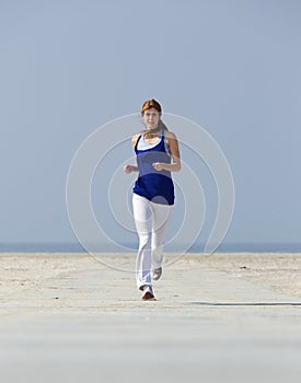 Middle aged woman jogging at the beach