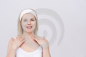 Middle-aged woman makes self-massage of the face, neck and decollete photo