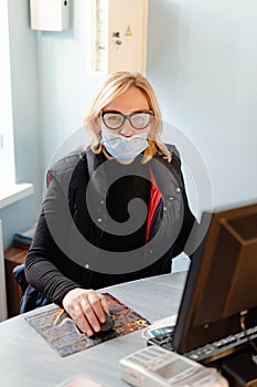 Middle aged woman with medical mask working with pc computer. Small business owner on quarantine