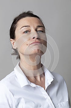 Middle aged woman with mole posing with chin up for arrogance