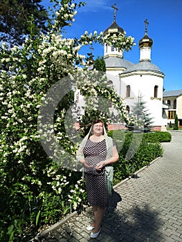 Middle-aged woman next to a bush of blooming jasmine