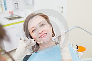 Middle aged woman patient at the dentist drilling the tooth with a turbine and making dental fillings