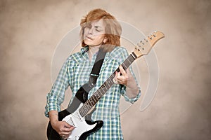 Middle aged woman playing electric guitar